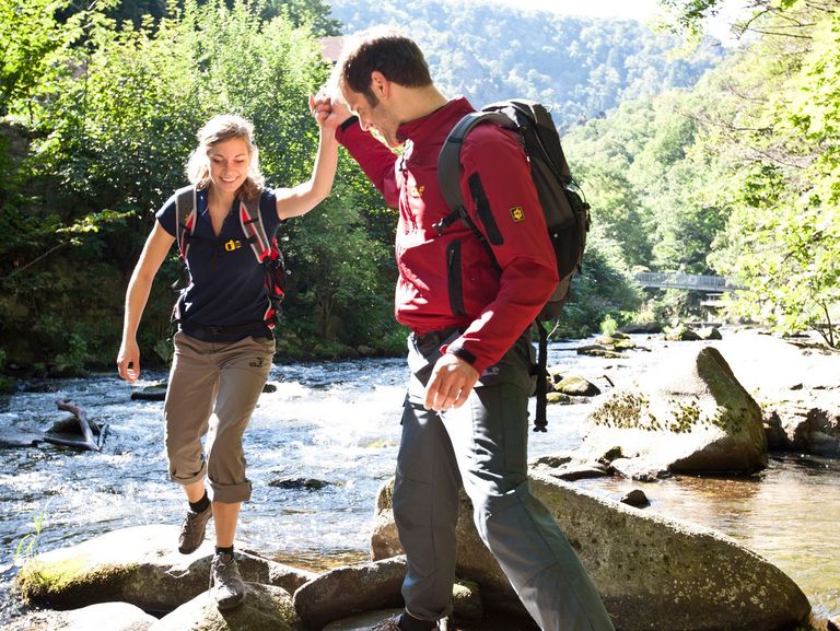 Mann und Frau wandern an einem Bach