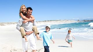 Glückliche Familie macht einen Strandspaziergang