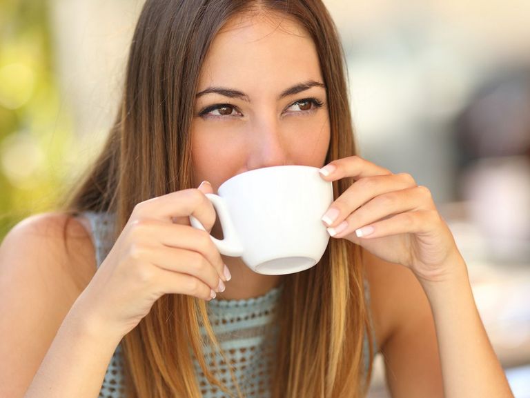 junge Frau trinkt Ihren Kaffee auf der Terasse eine Restaurants
