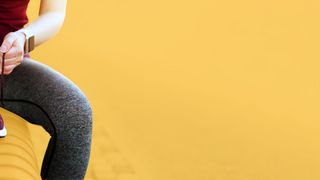 Sportlerin bindet sich auf einer Bank die Schuhe zu