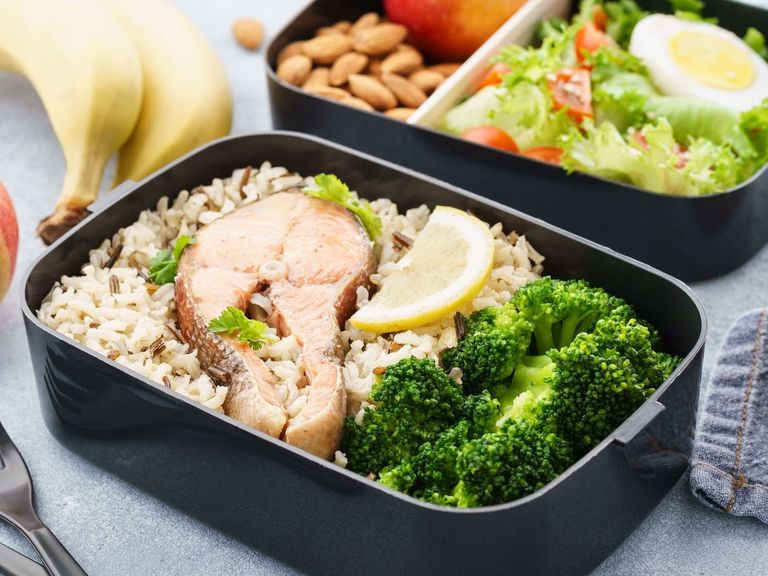 Vorgekochtes Mittagessen mit Lachs, Reis und Brokoli aufbewahrt in einer Box