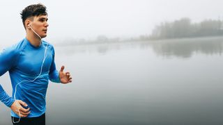 Aktiver Tagesausklang Junger Sportler mit blauem Oberteil joggt bei Tagesausklang