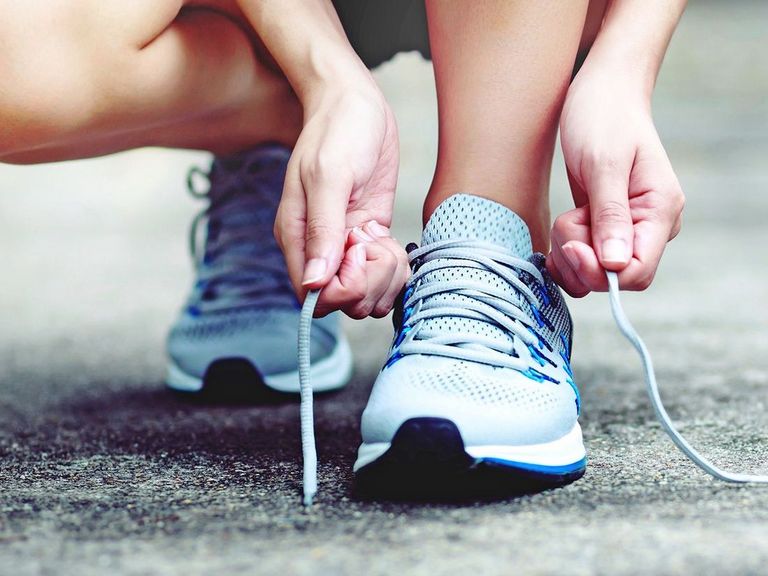 Läuferin bindet die Schnürsenkel ihrer Laufschuhe zu