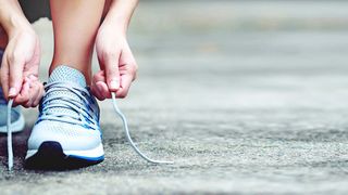 Läuferin bindet die Schnürsenkel ihrer Laufschuhe zu