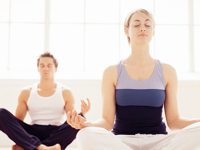 Mann und Frau betreiben Yoga