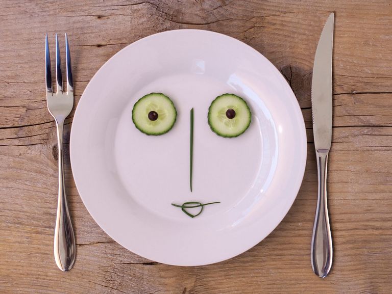 Gemüse formt ein Gesicht auf einem weißen Teller