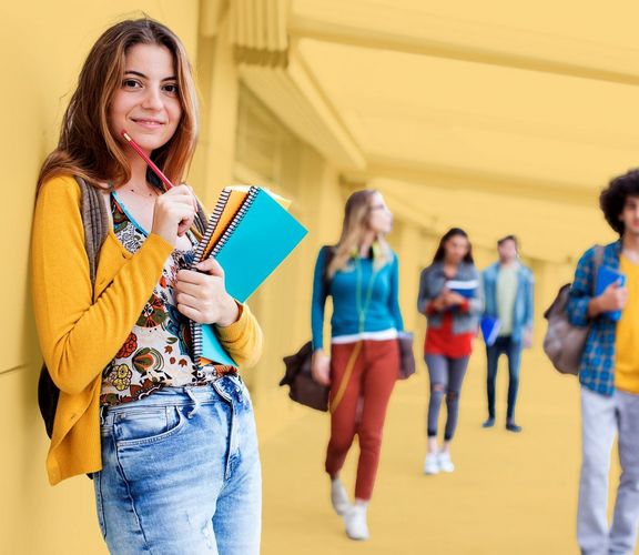 Junge Frau mit Schreibblöcken und Bleistift in der Hand