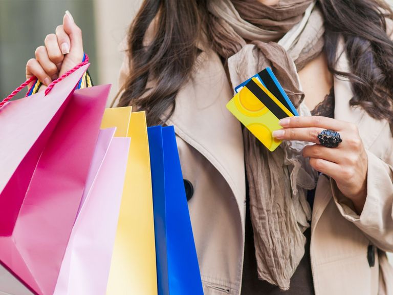 Frau trägt zuviele Einkaufstüten