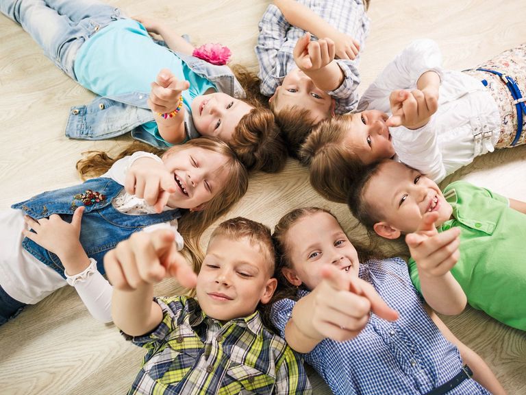 Kinder schauen und zeigen nach oben in die Kamera