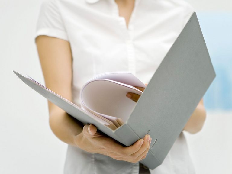 Frau blättert in einem Aktenordner