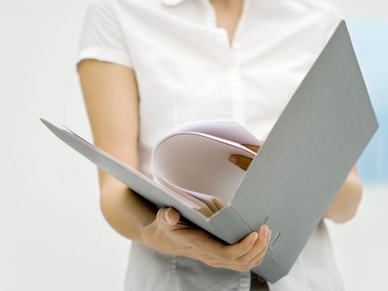 Frau hält Dokumentenordner