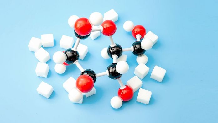 Kohlenhydrate Zucker und chemische Kohlenhydratmodelle auf blauem Hintergrund