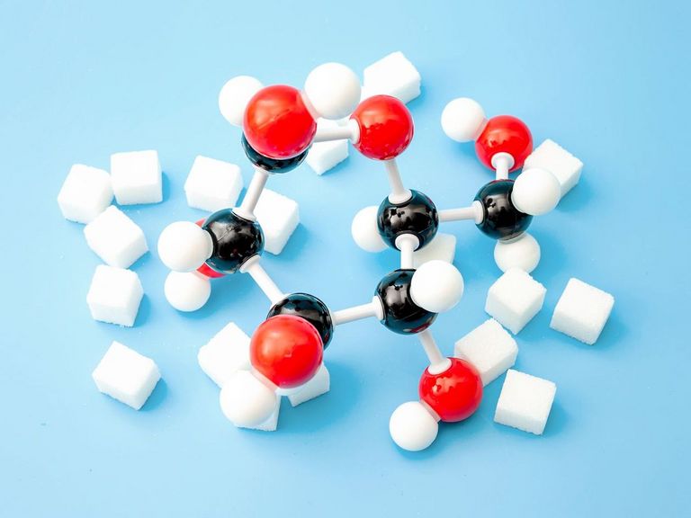 Zucker und chemische Kohlenhydratmodelle auf blauem Hintergrund