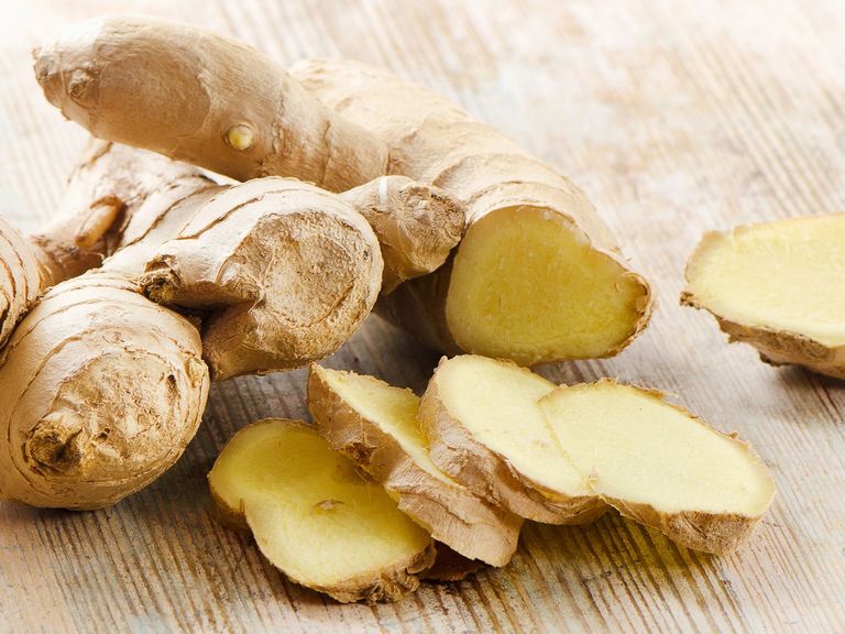 Ingwerwurzel und -stücke auf einem Holztisch