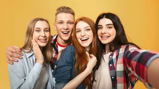 Vier Jugendliche schauen fröhlich in die Selfiekamera