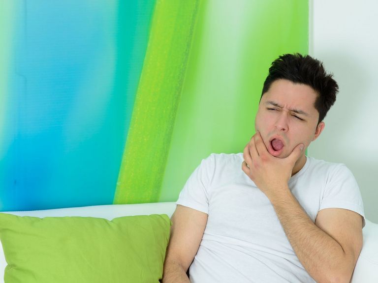 Mann spürt die Folgen vom Zähneknirschen im Schlaf