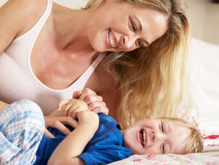 Mutter kitzelt ihren Sohn aus und beide lachen