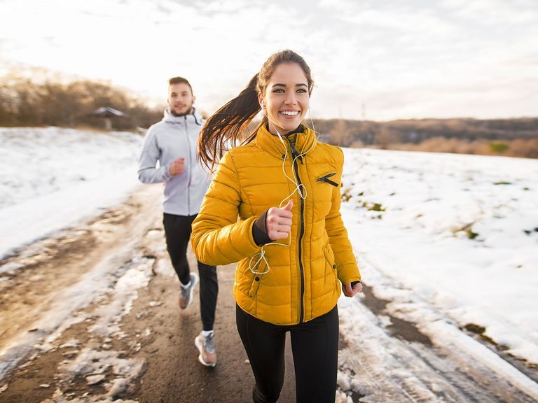 Pärchen in winterlicher Laufkleidung beim Joggen