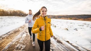 Pärchen in winterlicher Laufkleidung beim Joggen