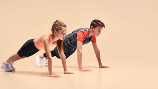 Mädchen und Junge mit Sportkleidung in der Liegestützposition