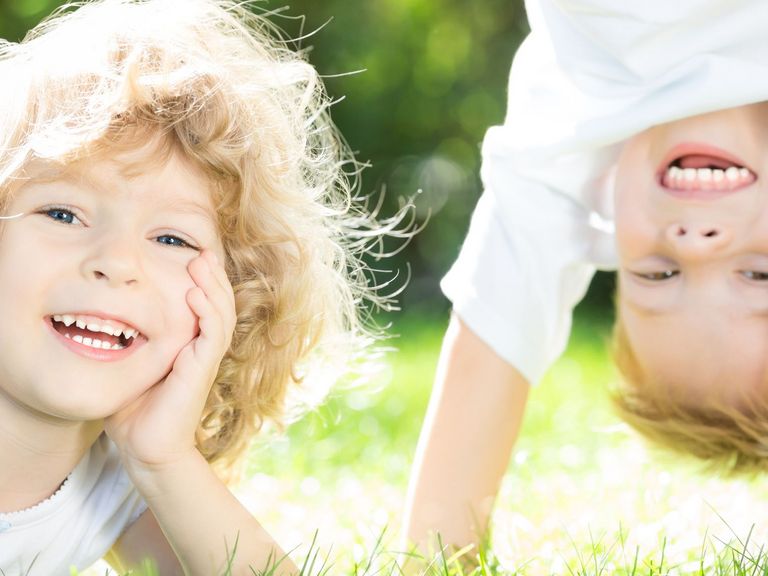 Zwei Kinder spielen fröhlich auf einer Wiese