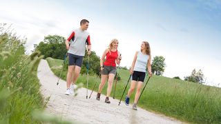 Familie betreibt Nordic Walking an der frischen Luft