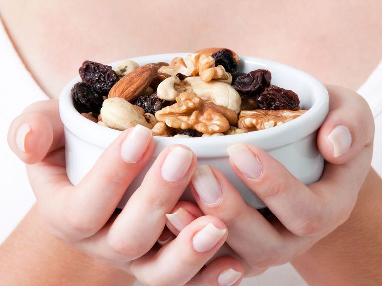 Frau hält eine Schale mit Studentenfutter