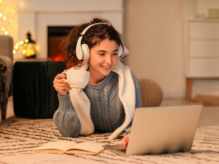 Frau mit Kopfhörer entspannt Mit einem Heißgetränk