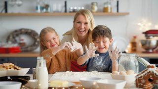 Mutter backt mit ihren zwei Kindern in der Küche Plätzchen