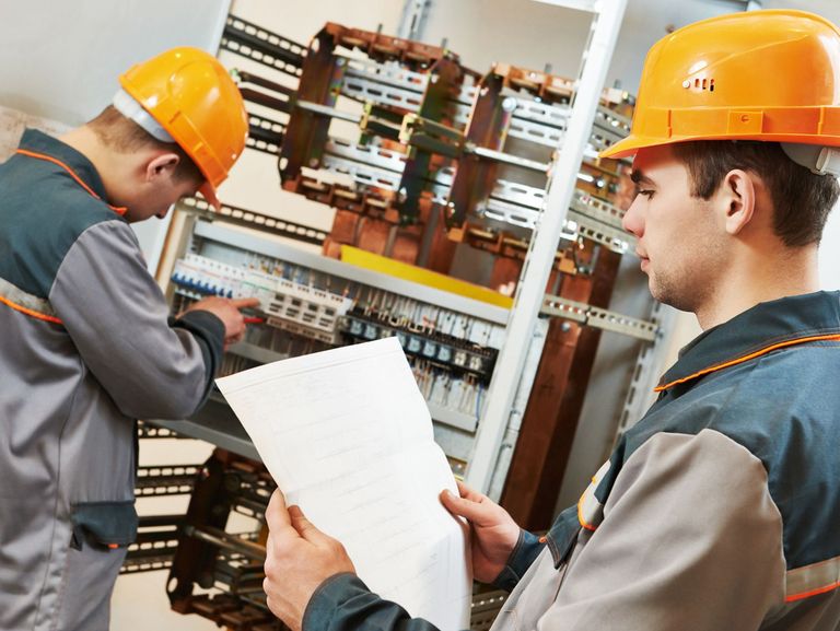Zwei Elektrotechniker arbeiten am Schaltkasten