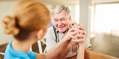 Pflegebedürftiger Rentner freut sich sehr über ein Gespräch mit der Pflegerin