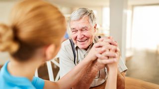 Pflegekasse Pflegebedürftiger Rentner freut sich sehr über ein Gespräch mit der Pflegerin