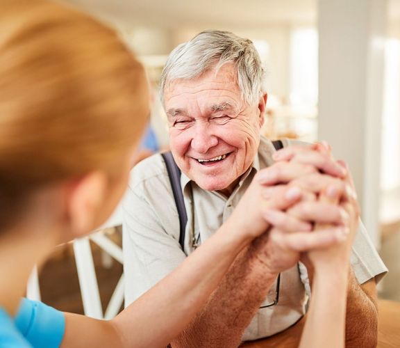 Pflegekasse Pflegebedürftiger Rentner freut sich sehr über ein Gespräch mit der Pflegerin