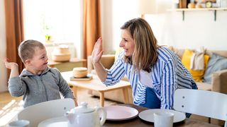 Pflege für Menschen mit Behinderungen Pflegerin kümmert sich mit viel Freude um ein behindertes Kind