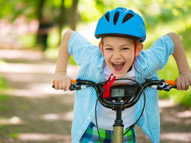 Fröhlicher Junge mit seinem Fahrrad
