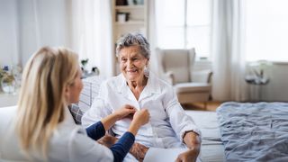 Pflegebedürftige Pflegebedürftige Rentnerin bekommt Hilfe beim Anziehen von einer Pflegekraft