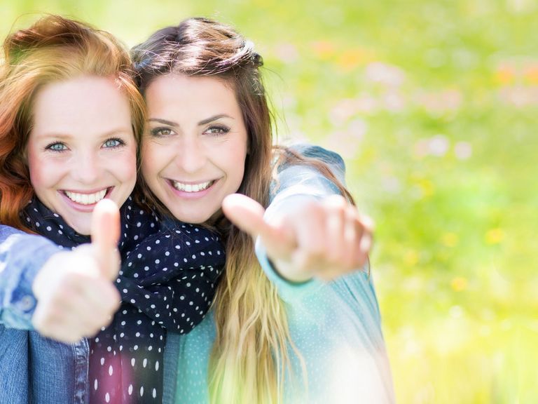 Zwei junge Frauen zeigen ihre Daumen hoch