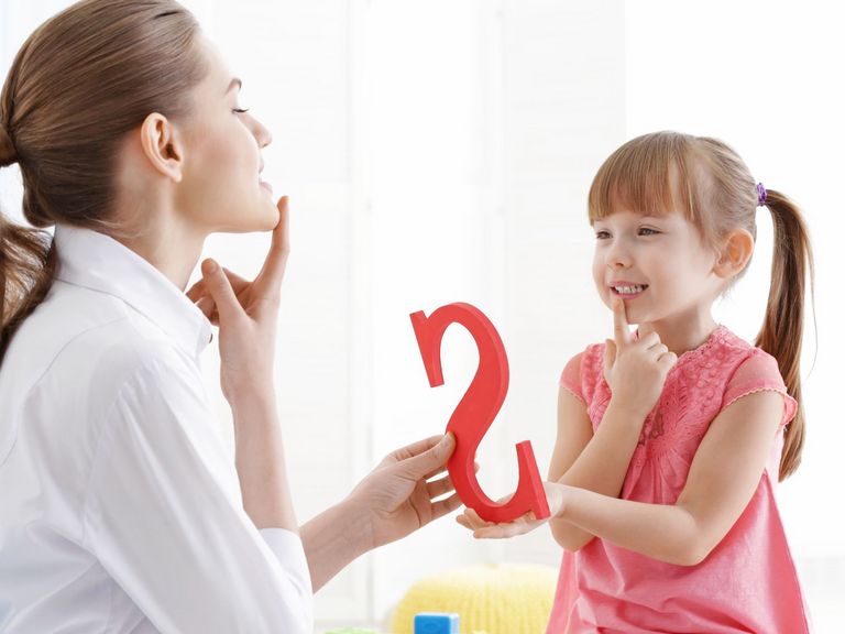 Logopädin übt den S-Laut mit einem kleinen Mädchen