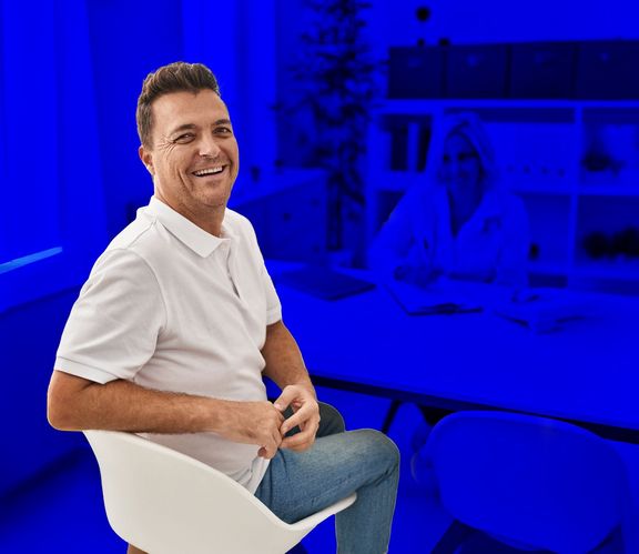 Mann beim Arztgespräch schaut über die Schulter zurück