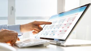 Terminvereinbarung Männerhand zeigt auf einen Terminkalender im Laptop-Bildschirm