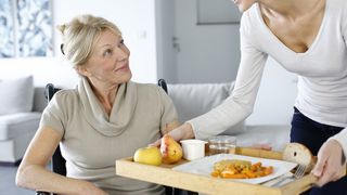 Junge Frau hilft einer Seniorien zu Hause