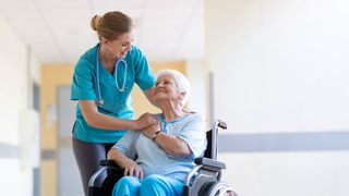 Kurzzeitpfleg Stationspflegerin betreut eine Pflegebedürftige im Rollstuhl