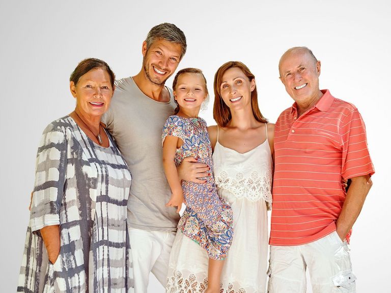 3-Generationen-Familie in Sommerkleidung vor einem grauen Hintergrund