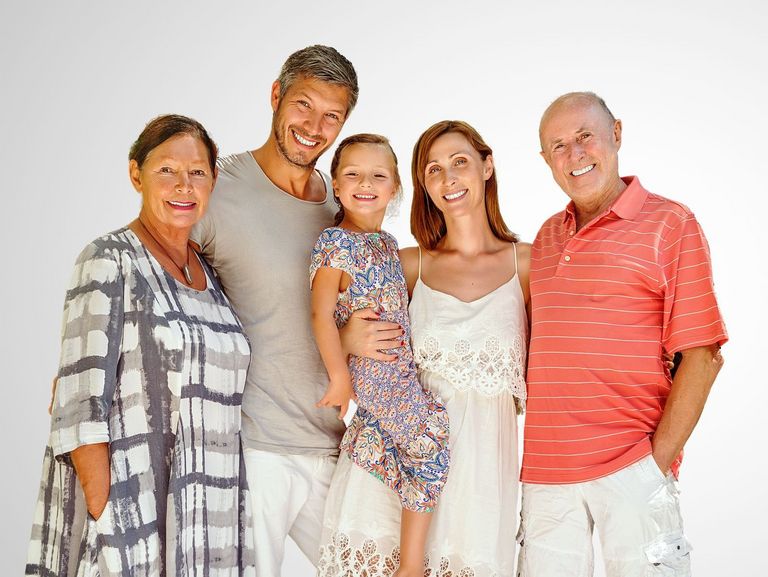 3-Generationen-Familie in Sommerkleidung vor einem grauen Hintergrund