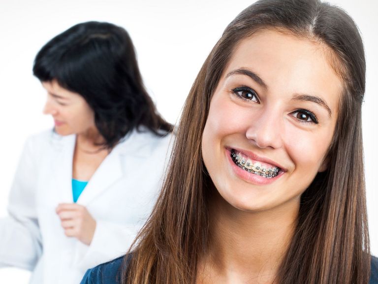 Junges Mädchen mit Zahnspange lacht in die Kamera