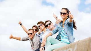 #bringabestie Gruppe Jugendlicher mit Sonnenbrillen sitzen auf einer Mauer und jubeln mit Daumen hoch