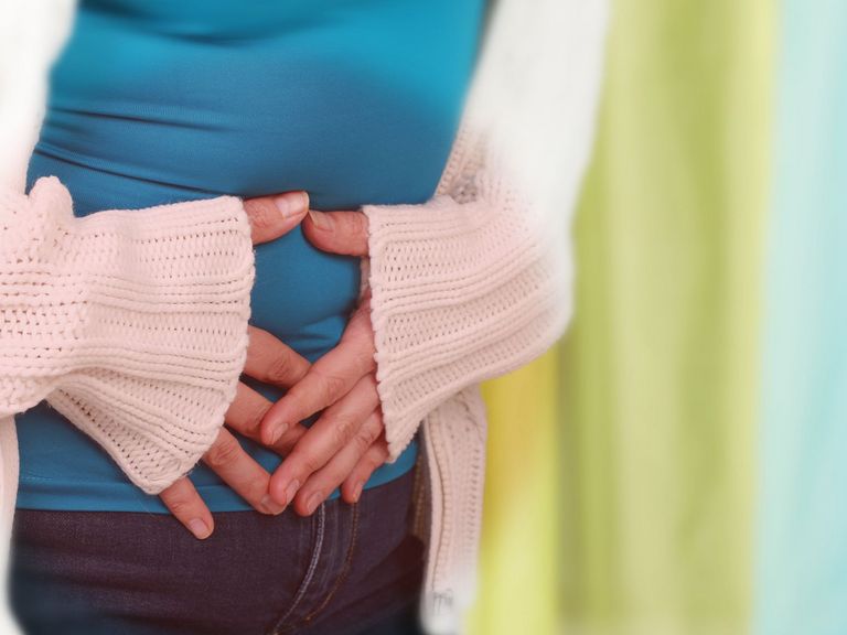 Frau hat Norovireninfektion und hält sich den Bauch