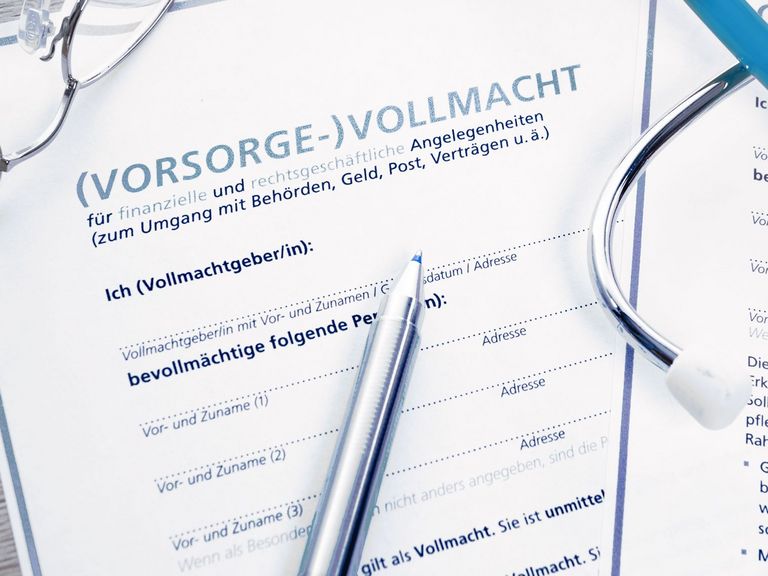 Vorsorgevollmacht, Kugelschreiber und Brille liegen auf einem Tisch