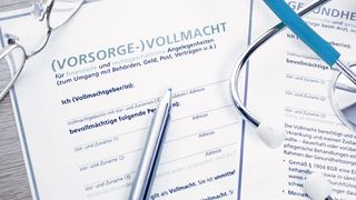 Vorsorgevollmacht, Kugelschreiber und Brille liegen auf einem Tisch