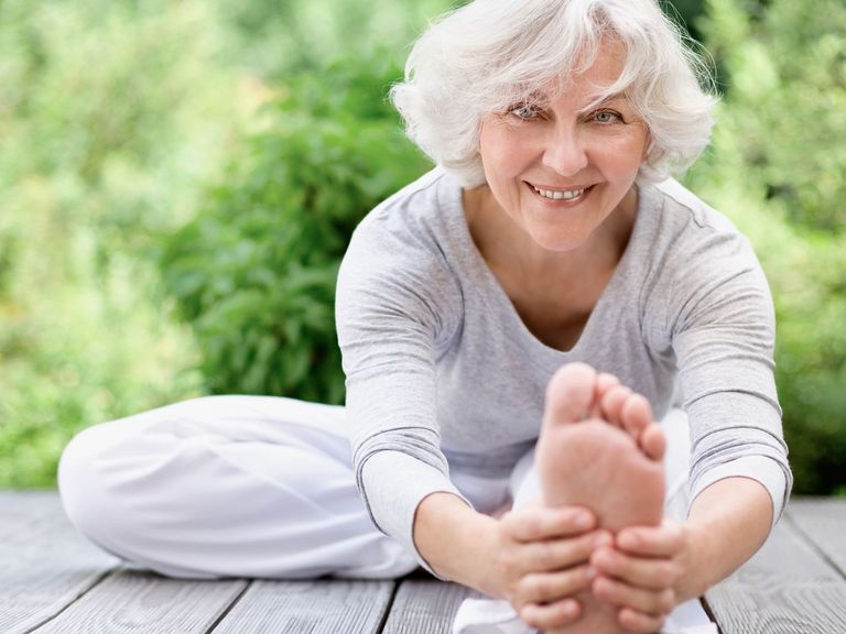 Sportliche Seniorin beim Streching im Freien